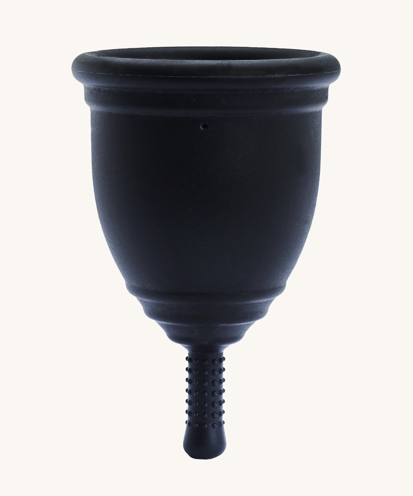 Ruby Cup Menstrual Cup in black silicone, on a cream background