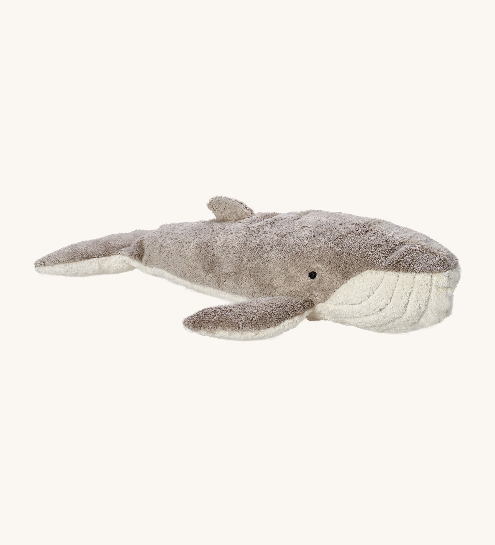 Senger Large Cuddly Whale, is a soft plush whale teddy with a grey and white body and a white mouth with small black eyes. The image is on a cream background