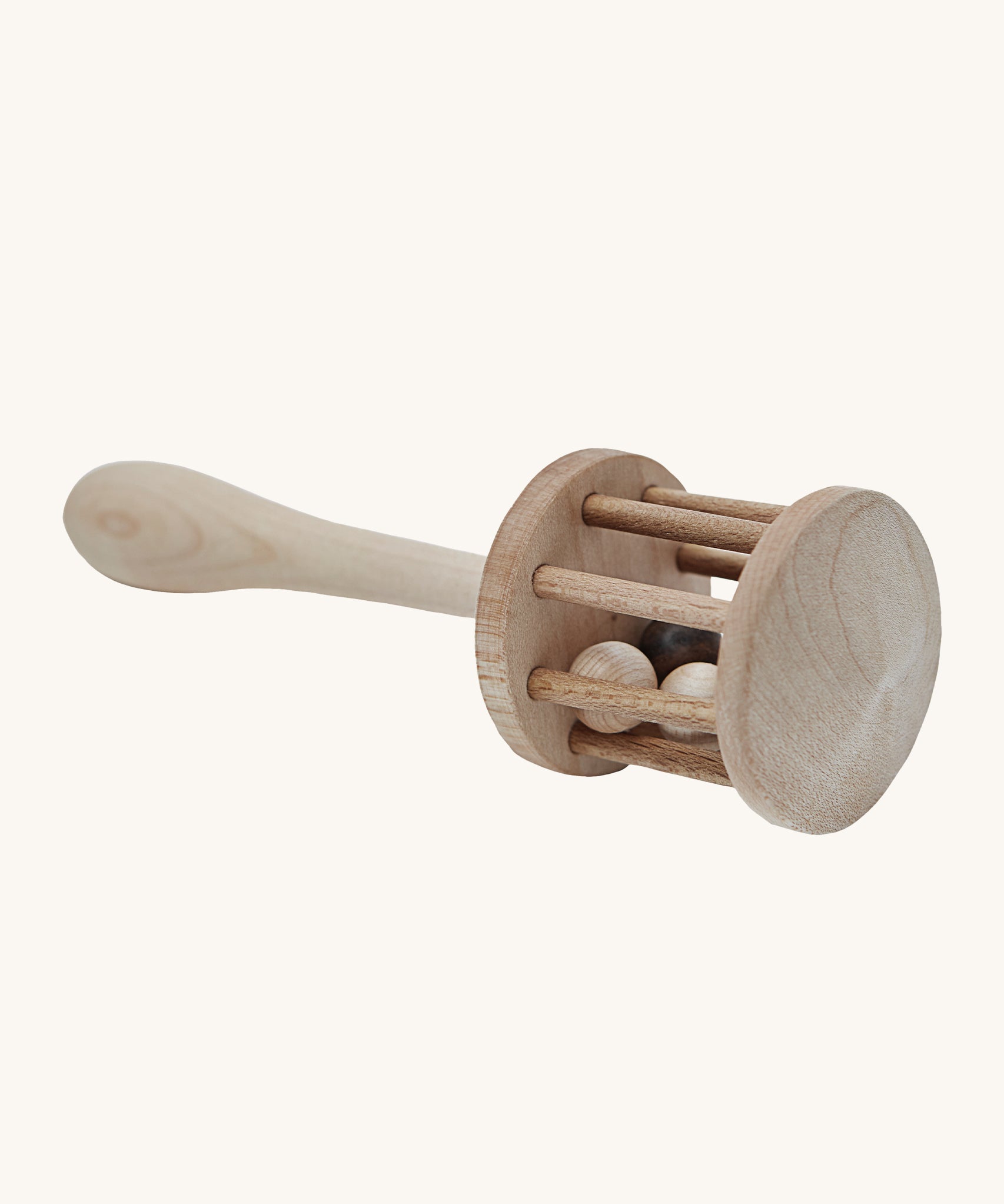 A view of the top of the rattle head, showing the wooden balls inside, on a cream background