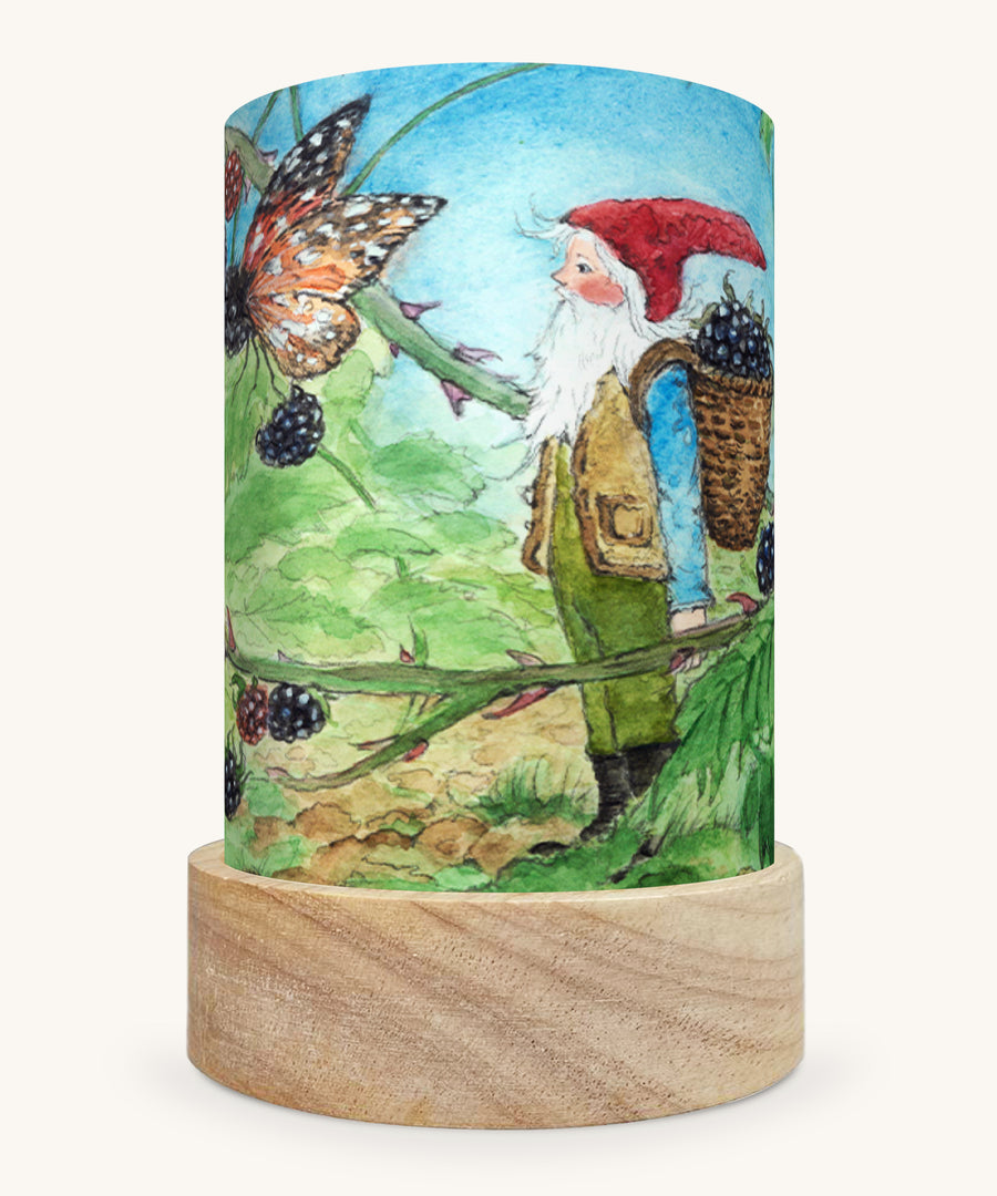 The Summer Gnome illustration by Eentje Van Margo sat in a Toverlux Magic Lantern base, on a cream background