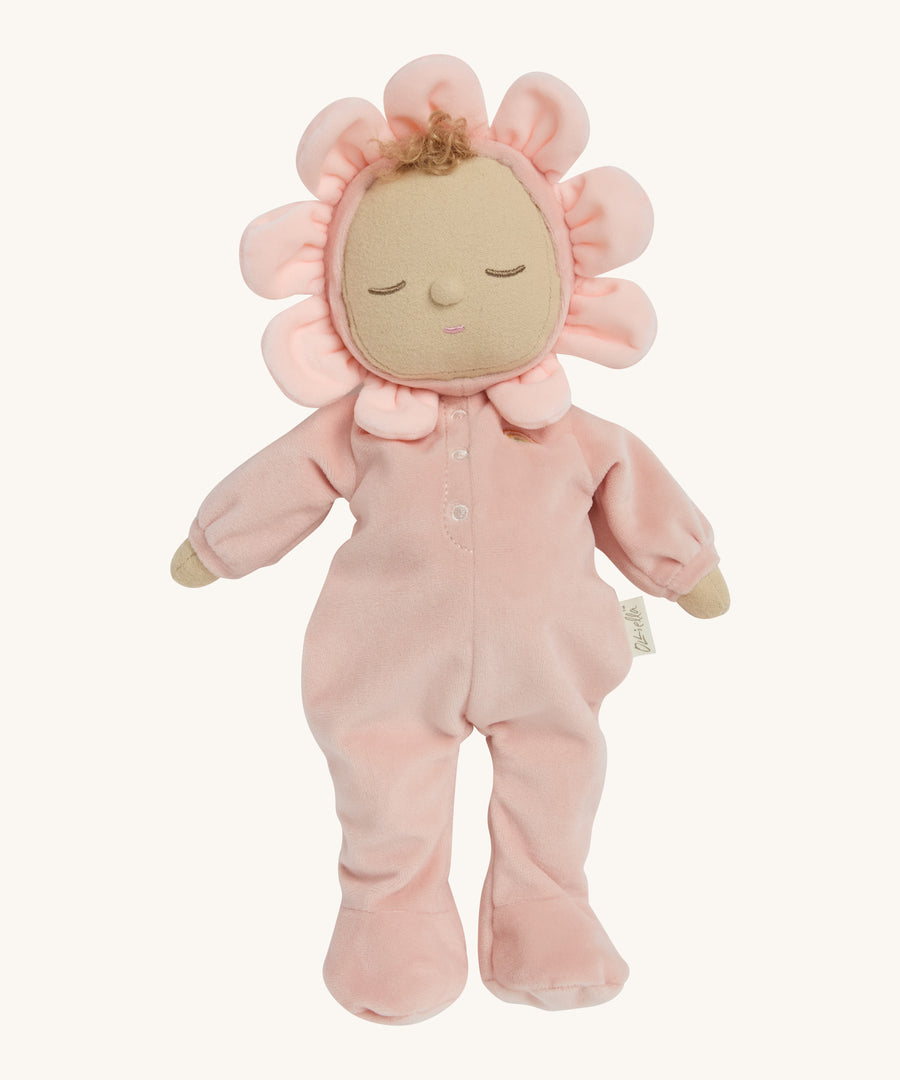 A light pink dozy dinkum doll standing up on a cream background.