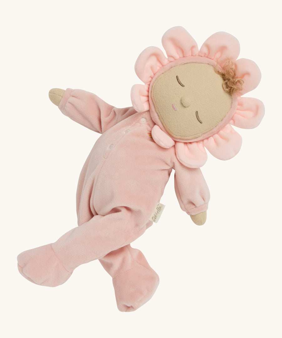 A light pink dozy dinkum doll posing on a cream background.