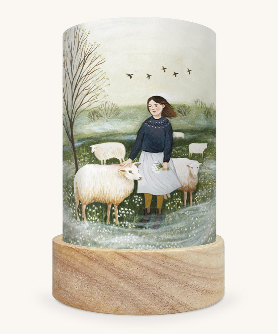 The Herdress illustration by Robin Pieterse sat in a Toverlux Magic Lantern base, on a cream background