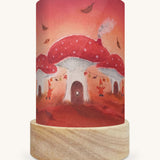 The Toadstool Village illustration by Baukje Exler sat in a Toverlux Magic Lantern base, on a cream background