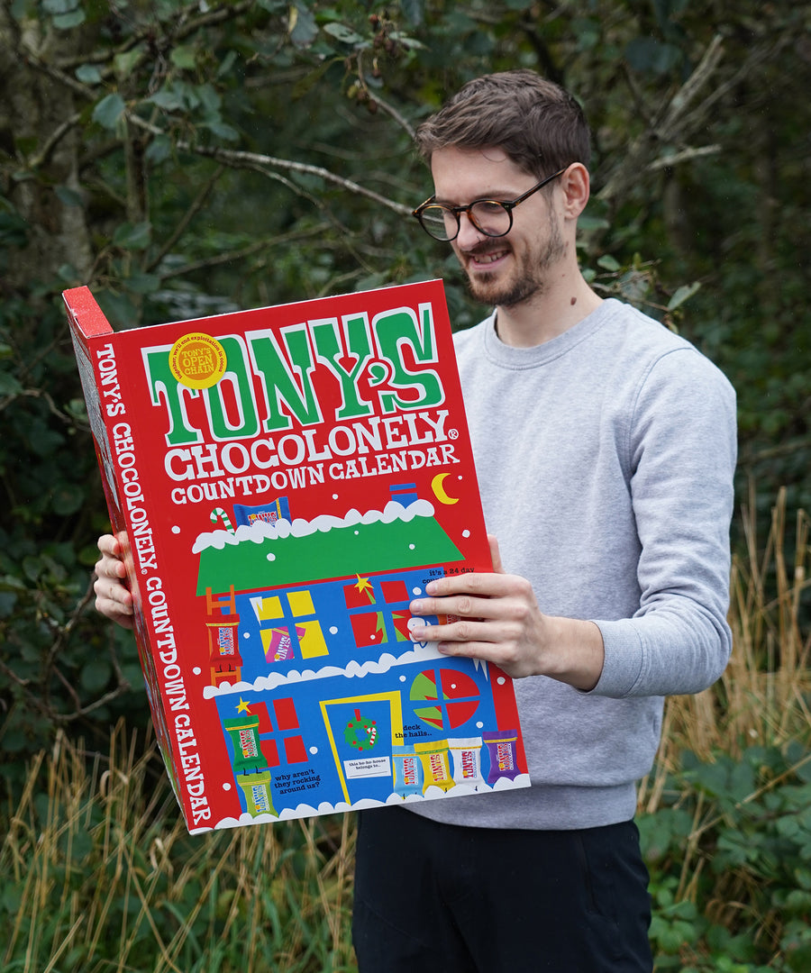 A person holding the Tony's Chocolonely Fairtrade Advent Calendar, looking inside at the delicious chocolates