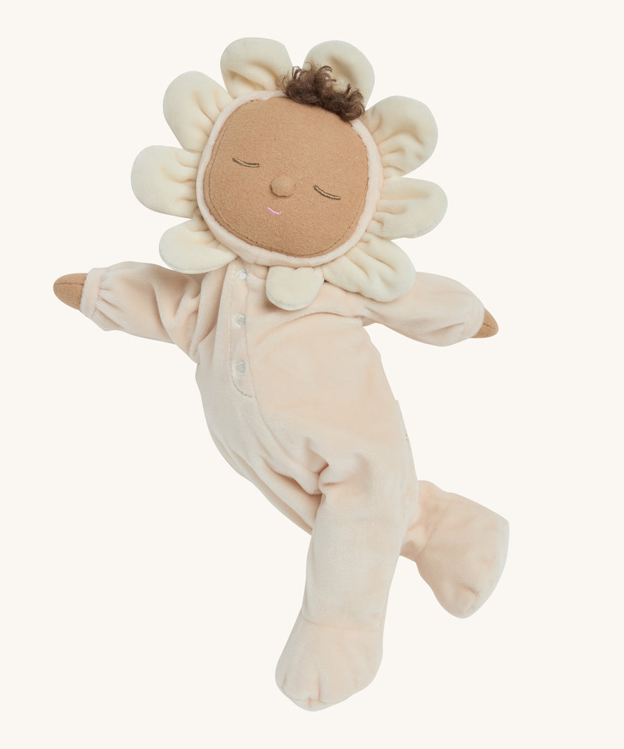 A light cream dozy dinkum doll posing on a cream background.