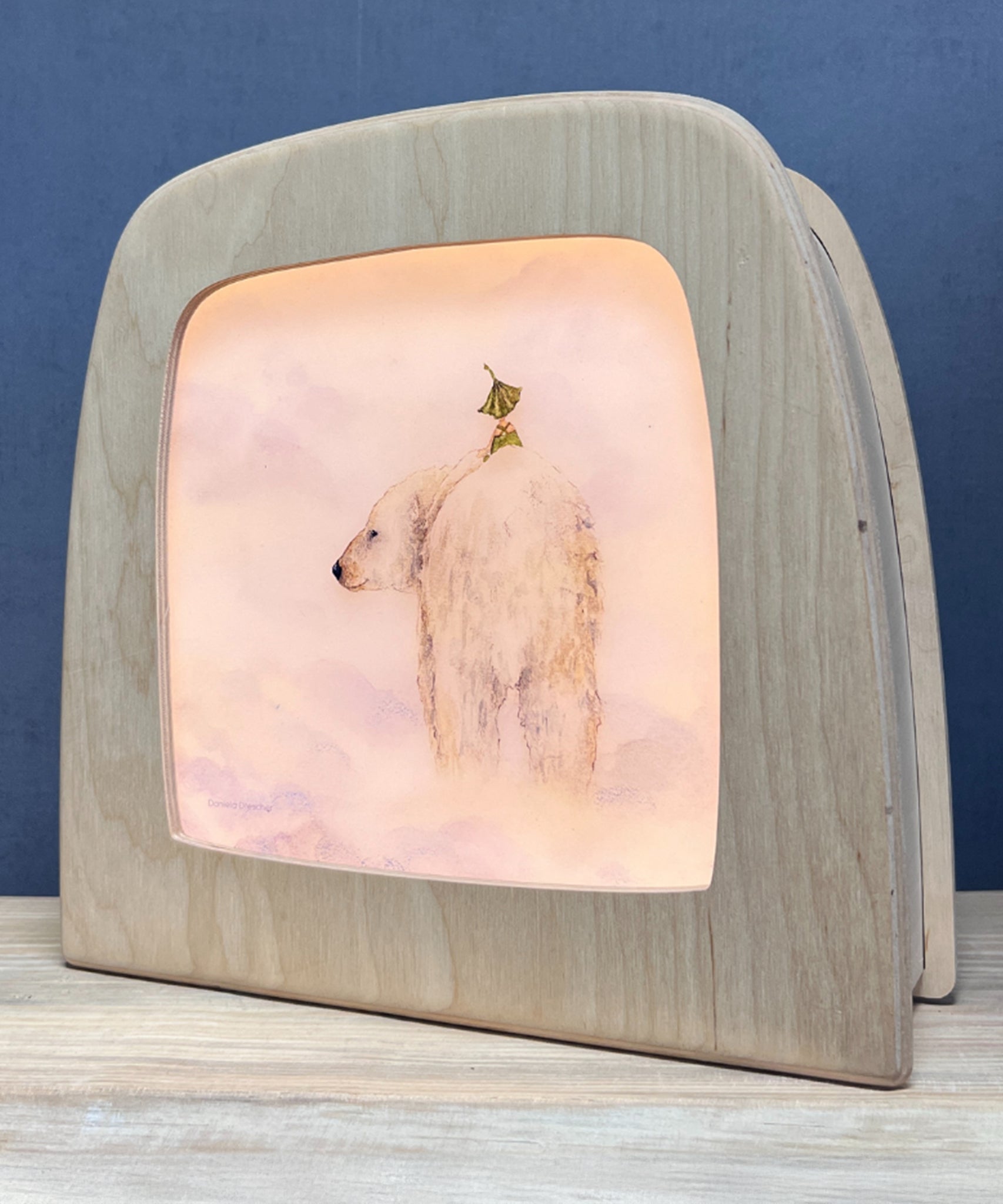 An illustration of a gnome sitting on the back of a polar bear from the Garden Adventures Of Griswald Gnome Toverlux StoryLux Silhouette Sets, by Daniela Drescher. The illustration is inside a Magic Lamp which is stood on a table