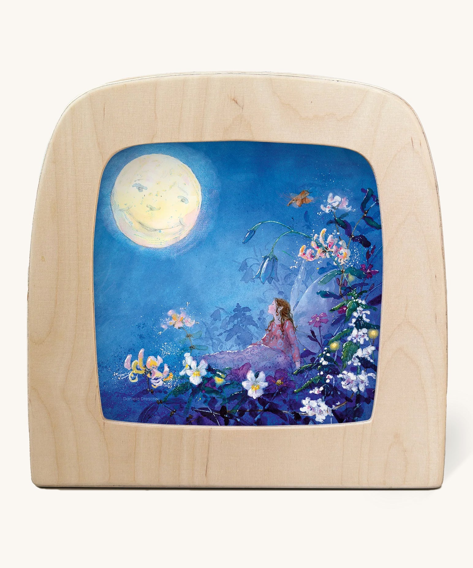 The Little Fairy Can't Sleep - Moon illustration by Daniela Drescher sat in a Toverlux Magic Lamp, on a cream background. The mage shows a fairy laying in bed underneath colourful flowers with a full moon in the sky