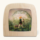 Toverlux Magic Lamp Silhouette - Artwork By Het Wol Feetje, Little Explorer. A felt illustration of a person walking in a grassy area with a rabbit following behind. The image is on a cream background