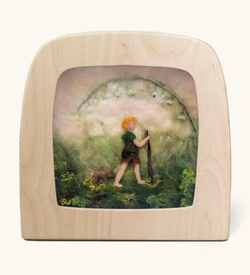 Toverlux Magic Lamp Silhouette - Artwork By Het Wol Feetje, Little Explorer. A felt illustration of a person walking in a grassy area with a rabbit following behind. The image is on a cream background