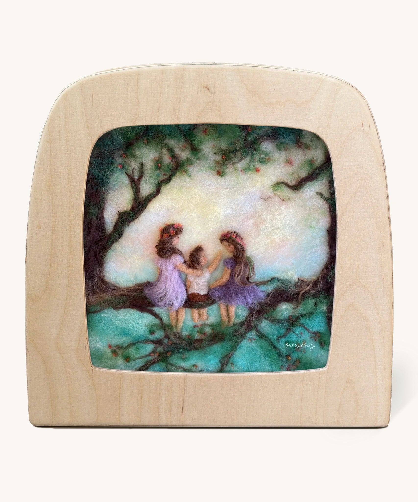 Toverlux Magic Lamp Silhouette - Artwork By Het Wol Feetje, Siblings. Three felt children are sat in a large tree, on the tree branch and are looking at each other. The image is on a cream background