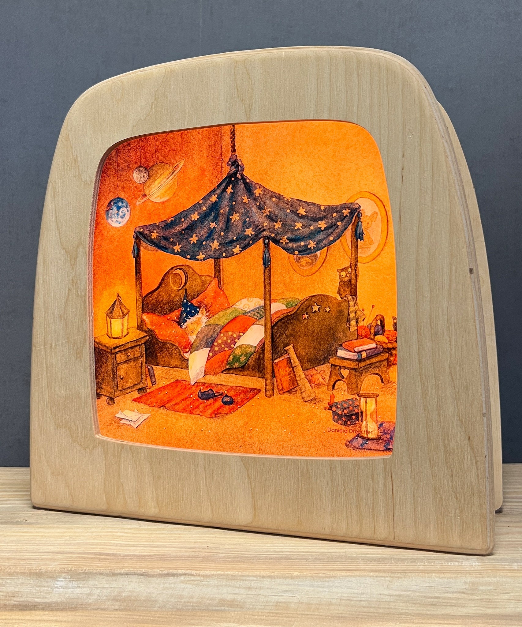 An illustration of a gnome asleep in its bed from the Goodnight Sandman Toverlux StoryLux Silhouette Sets, by Daniela Drescher. The illustration is inside a Magic Lamp which is stood on a table