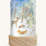 The Winter Forest illustration by Eentje Van Margo sat in a Toverlux Magic Lantern base, on a cream background