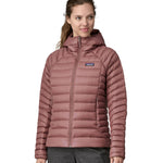 A person wearing the Patagonia Women's Down Sweater Hoody - Dulse Mauve. Perfect for cooler weather