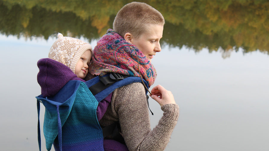 Woman carrying her baby in a blue Wompat baby carrier