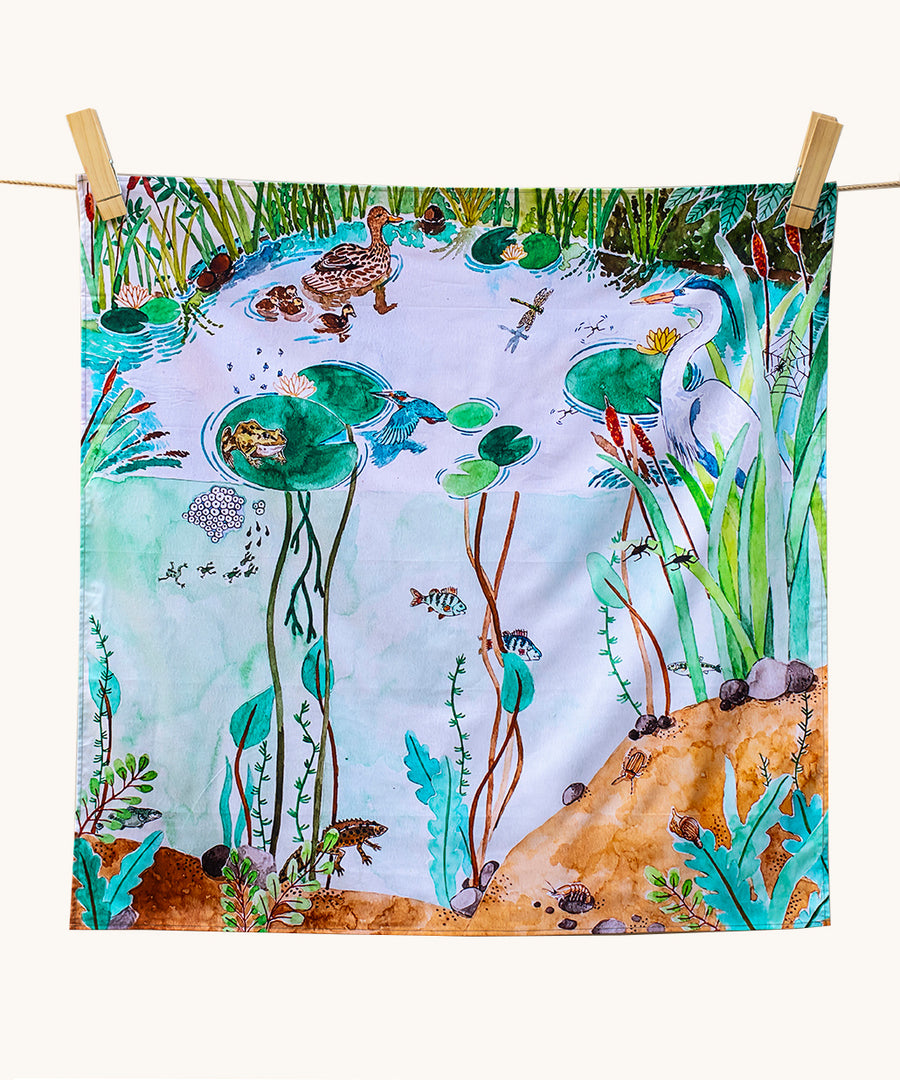 Wonderie Play Cloth - Down By The Pond. A beautiful play cloth depicting a busy pond scene with ducks, frogs, a heron, fish and dragonflies all playing among the reeds and lily pads