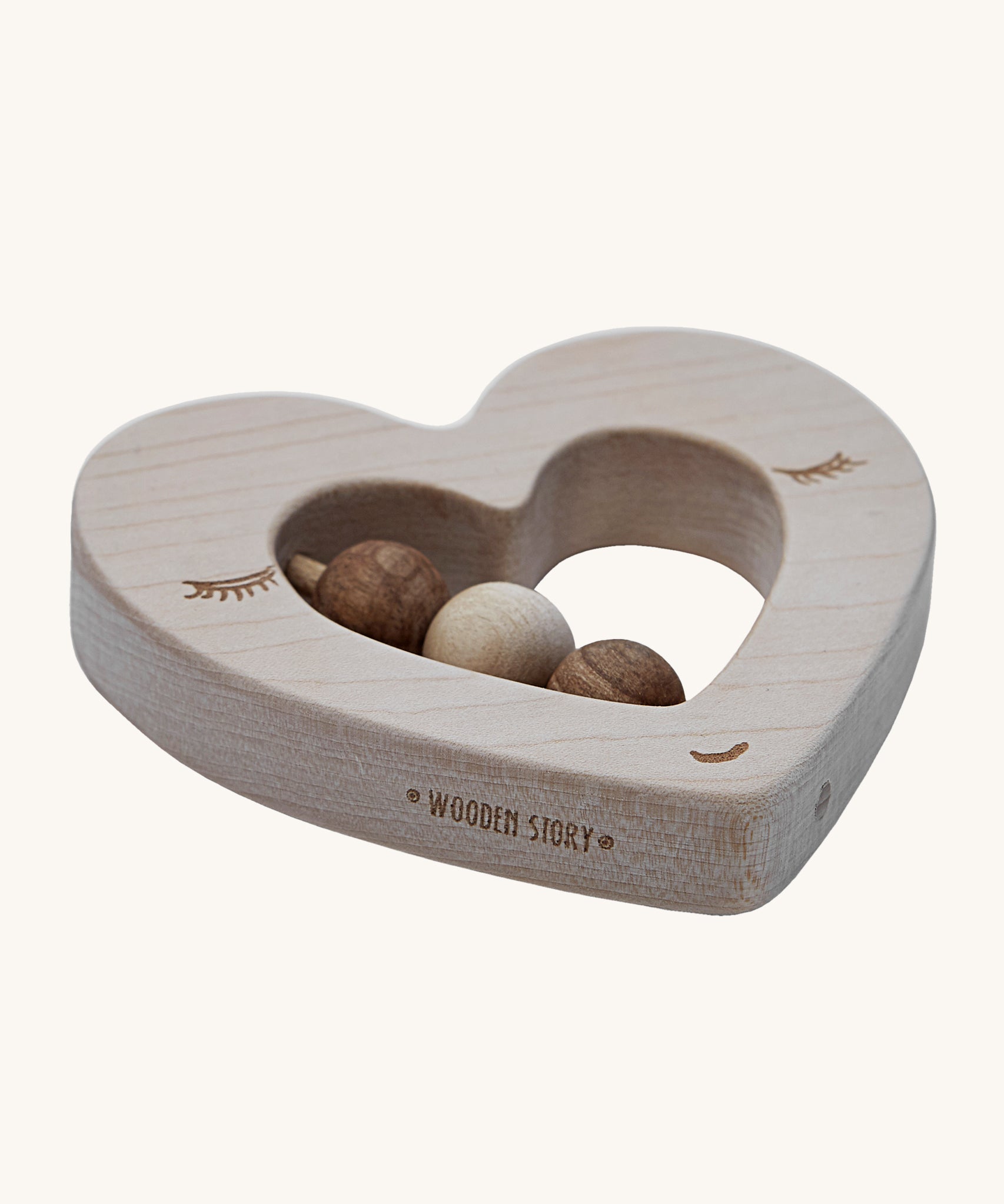 A side view of the Wooden Story Heart Rattle, showing the natural wood grain of the rattle, and the words "Wooden Story" etched onto the side of the rattle.