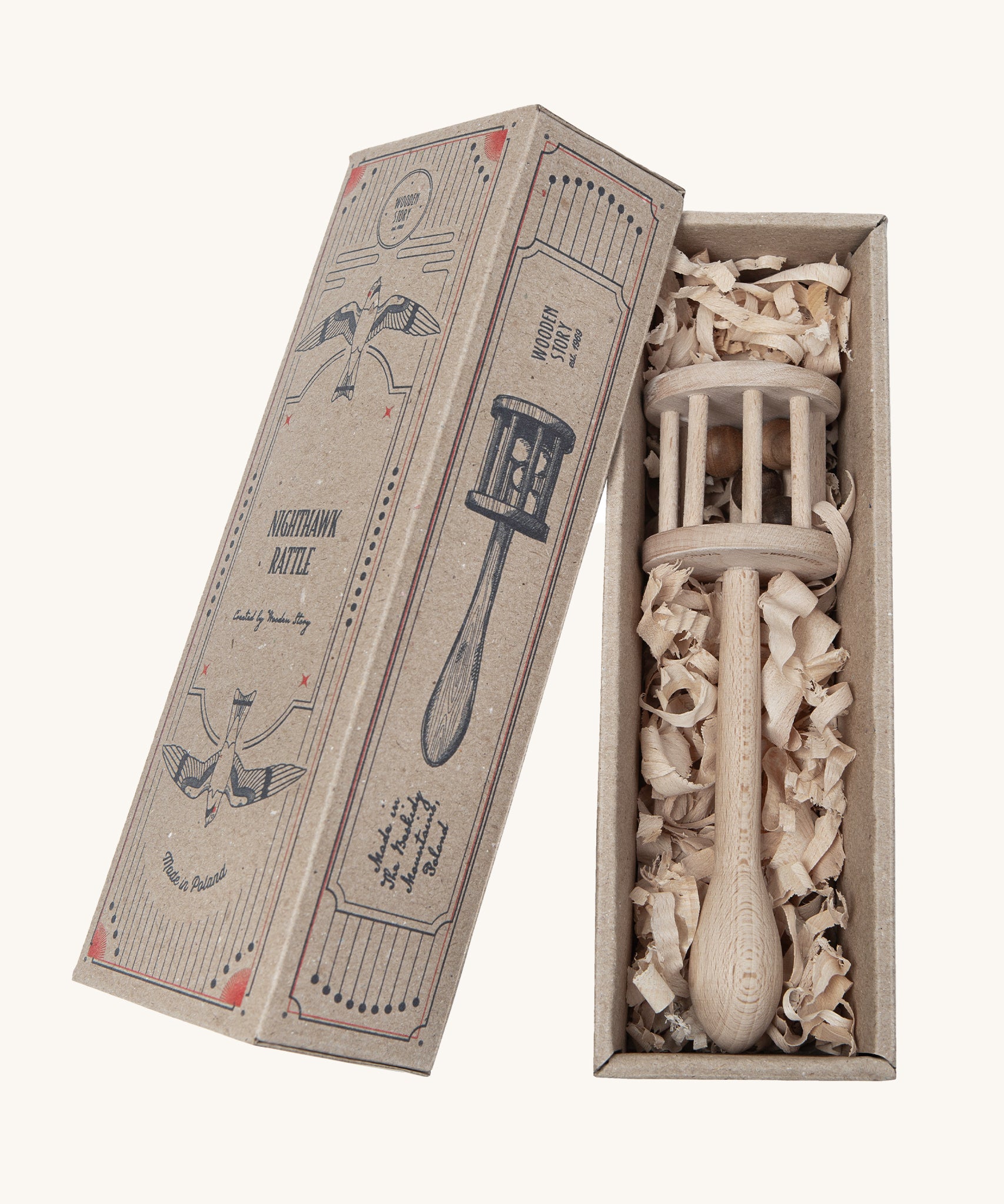 The Wooden Story Nighthawk Rattle comes in a vintage inspired, decorated cardboard box and is laid on wood shavings inside the box.