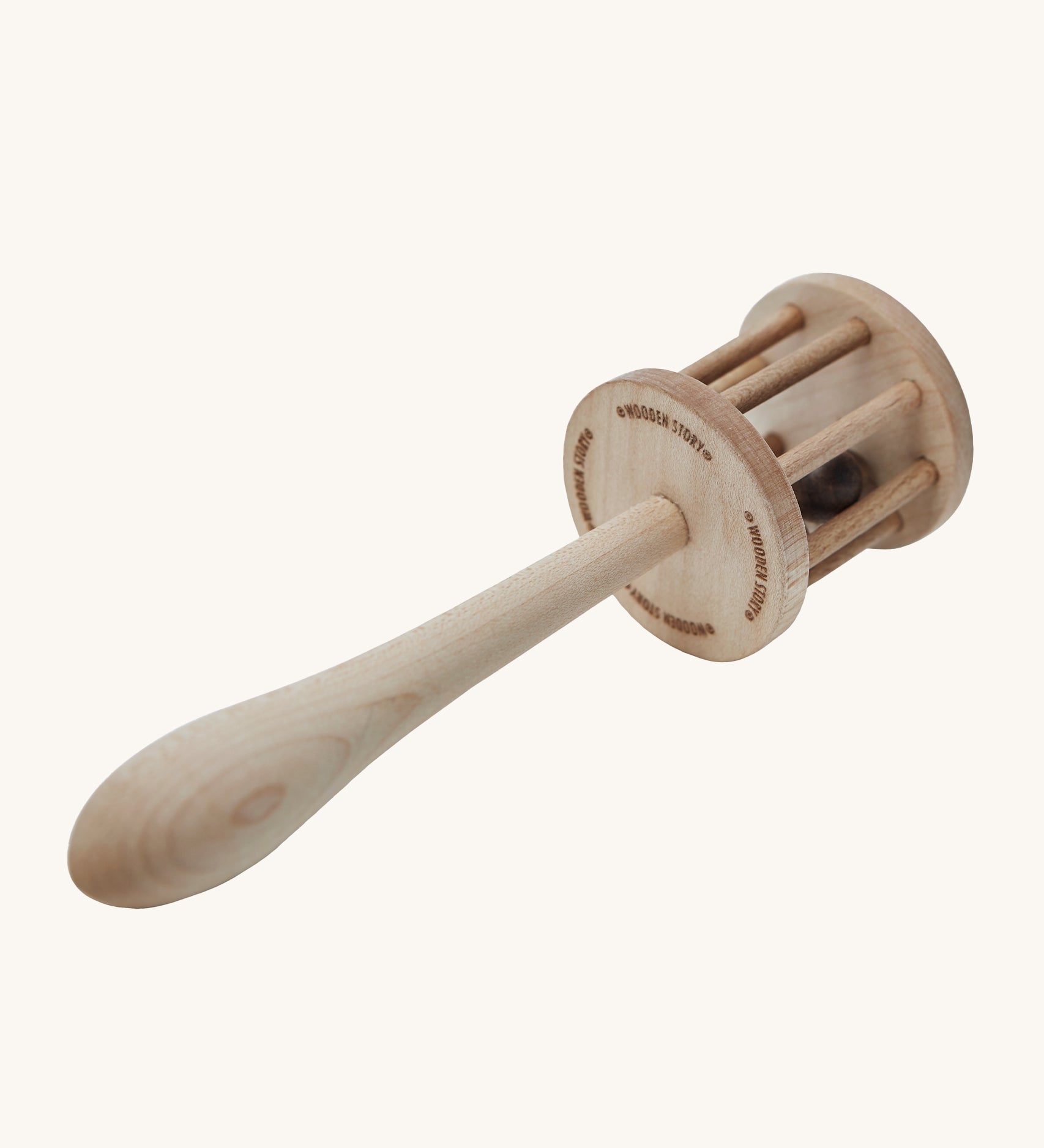 The underneath of the Wooden Story Nighthawk Rattle head, with the words "Wooden Story" etched onto the base. The image also shows the natural wood grain and is on a cream background