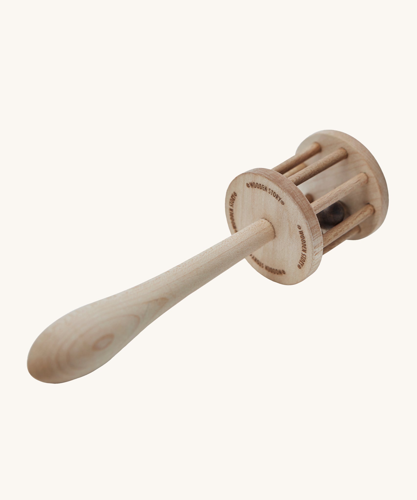 The underneath of the Wooden Story Nighthawk Rattle head, with the words "Wooden Story" etched onto the base. The image also shows the natural wood grain and is on a cream background