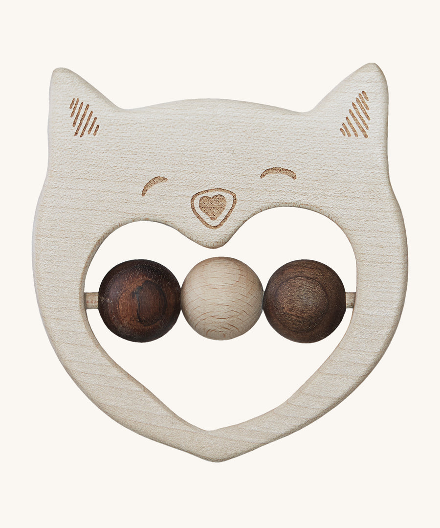 The Wooden Story Smiley Cat Rattle, is a beautiful wooden, sensory toy, perfect for teething. The rattle has a cat face on the front, and three wooden beads in the middle. 2 in dark wood and 1 in light wood. The image is on a cream background