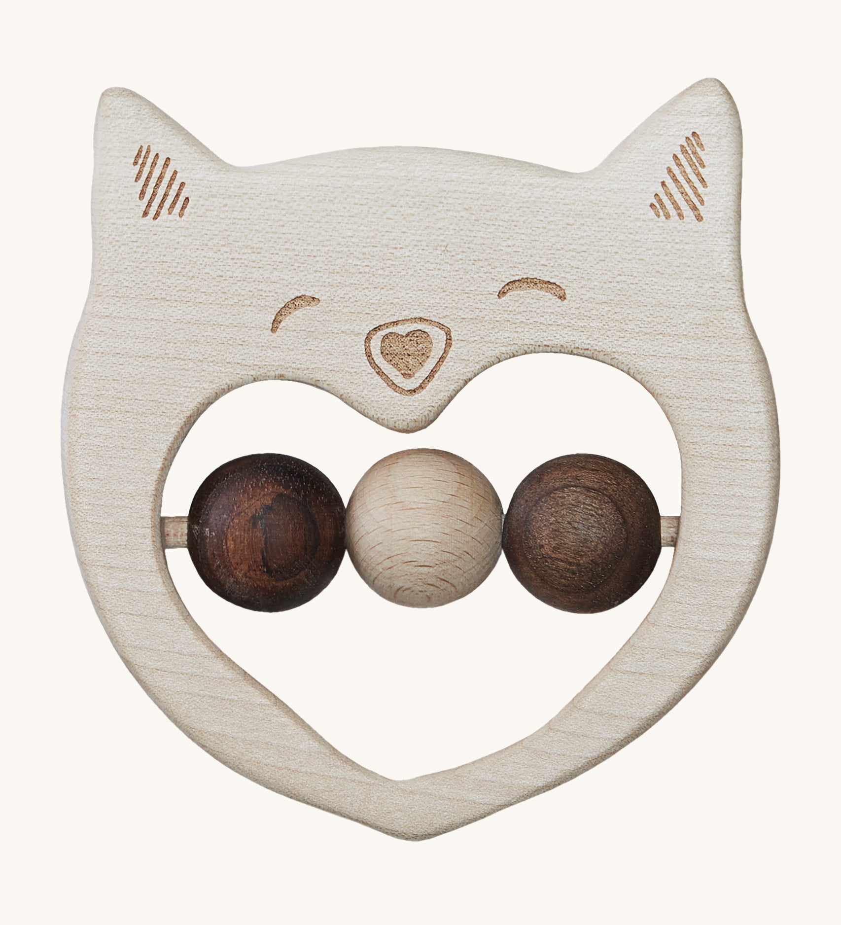 The Wooden Story Smiley Cat Rattle, is a beautiful wooden, sensory toy, perfect for teething. The rattle has a cat face on the front, and three wooden beads in the middle. 2 in dark wood and 1 in light wood. The image is on a cream background