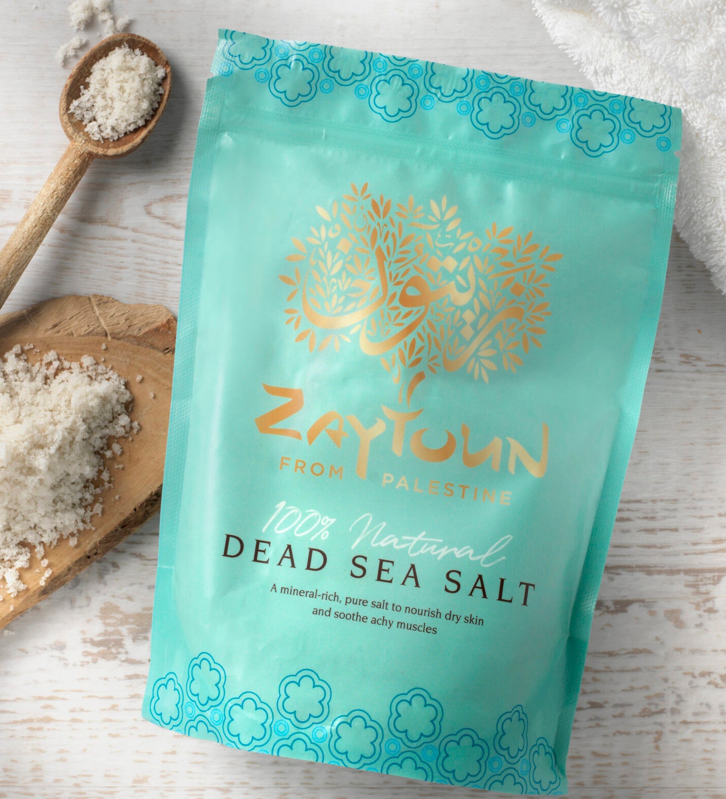 Zaytoun Dead Sea Bath Salts 750g, in a light blue packet with the sea salts on a wooden board, and in a wooden spoon