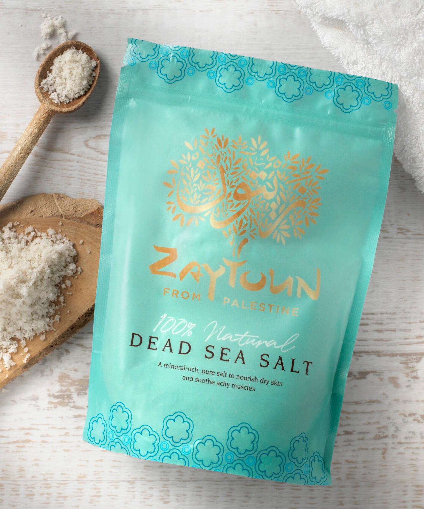 Zaytoun Dead Sea Bath Salts 750g, in a light blue packet with the sea salts on a wooden board, and in a wooden spoon