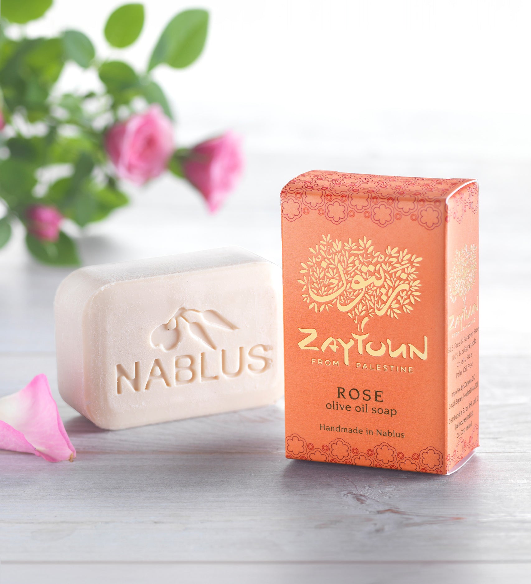 Zaytoun Pure Olive Oil Soap - Rose 100g. A beautiful rose scented Nablus soap bar, stood next to the box with a rose plant in the background