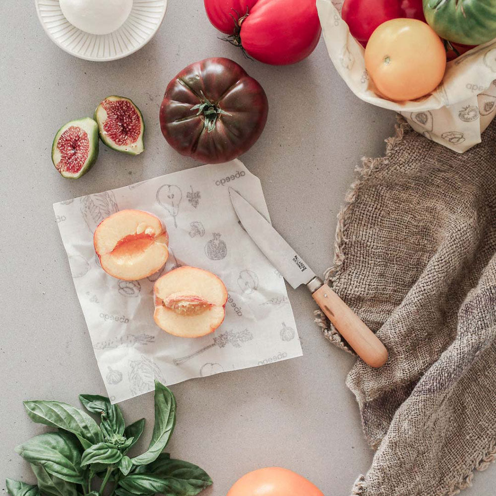 A sliced peach laid out on an Abeego natural beeswax food wrap