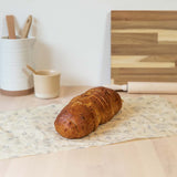 shaped into a bag and filled with leaves on a wooden worktop