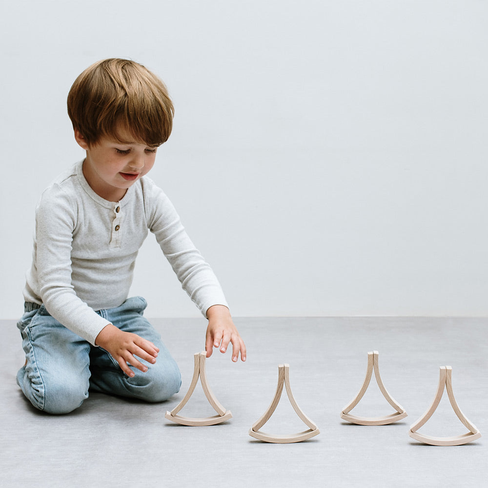 Boy playing with the 12 Mini Abel blocks toy set on a white background