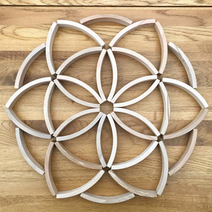 Abel mini wooden blocks built into a flower mandala pattern on a wooden floor