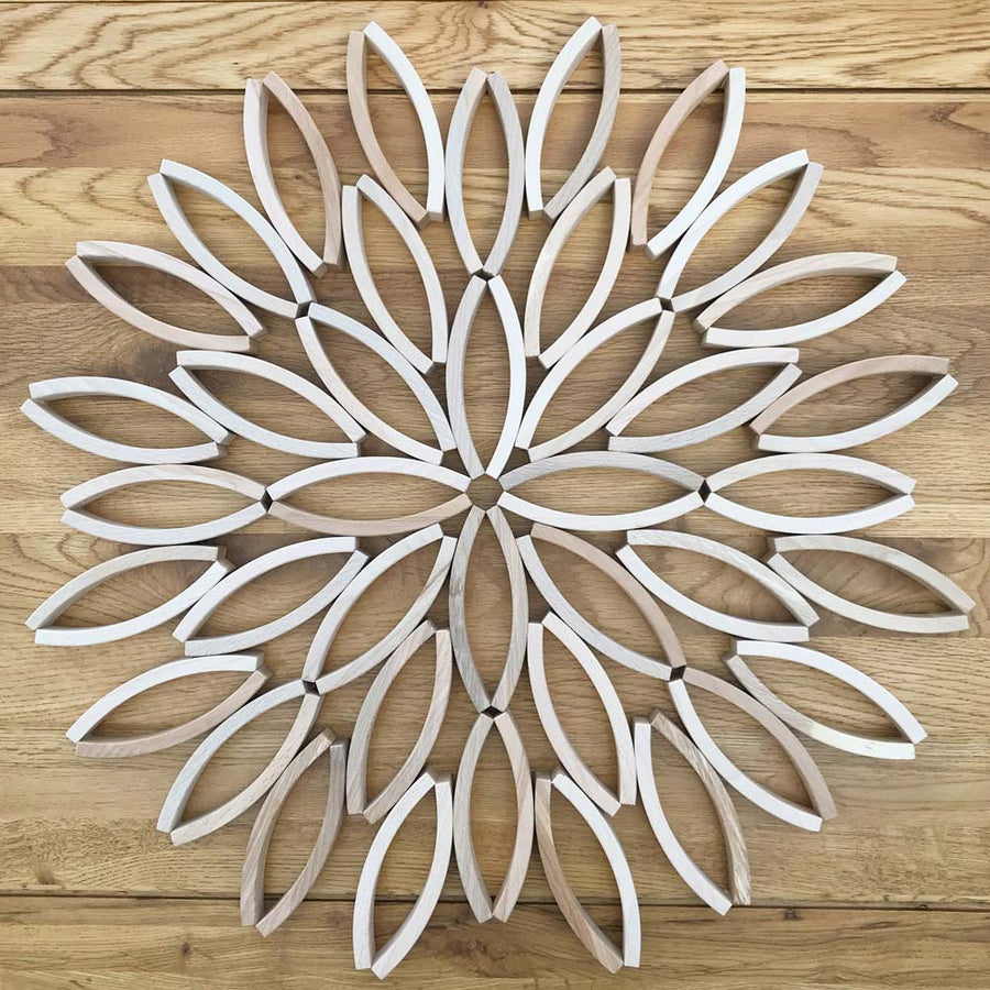 Abel mini plastic free wooden toy blocks arranged in a detailed flower mandala on a wooden floor