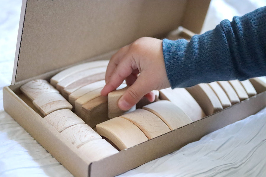 Close up of childs hand picking an Abel Golden Ratio toy block out from the box