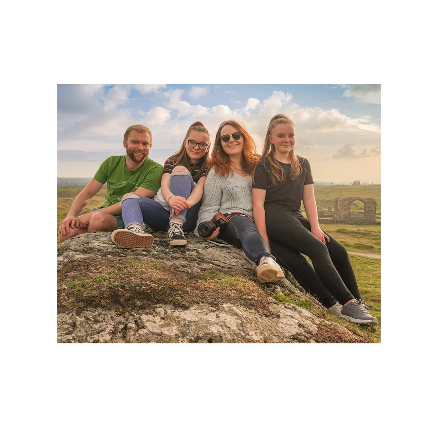 Jolene, Peter and their daughters sat on a rock outdoors