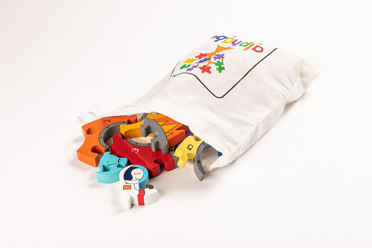 Alphabet Jigsaw wooden Rocket Number pieces pouring out of a white drawstring bag on a white background