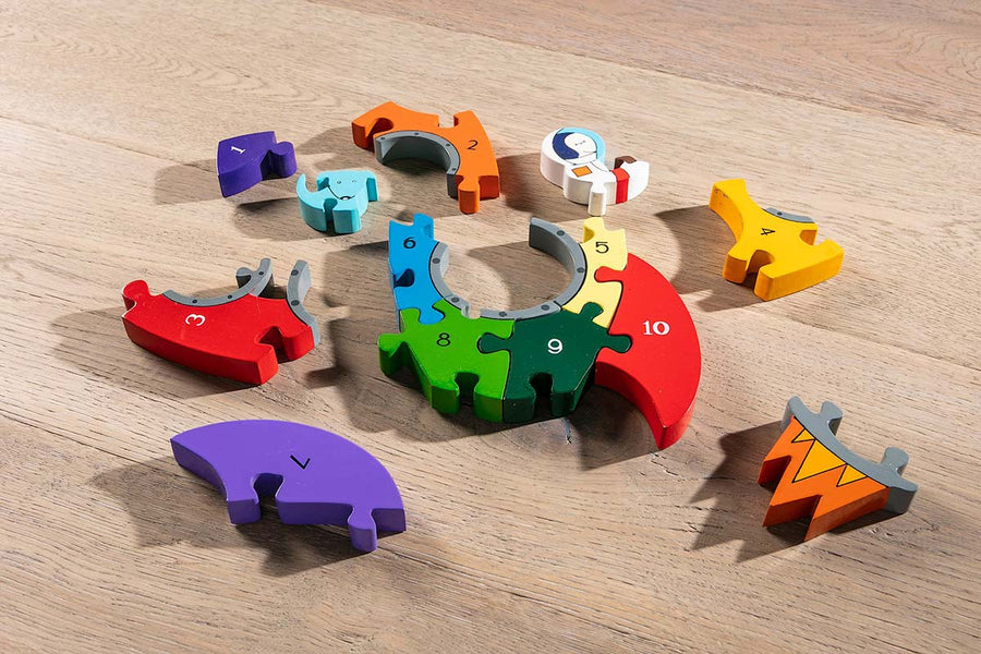 Alphabet Jigsaw eco-friendly multicoloured rainbow Rocket puzzle pieces laid out on a wooden background