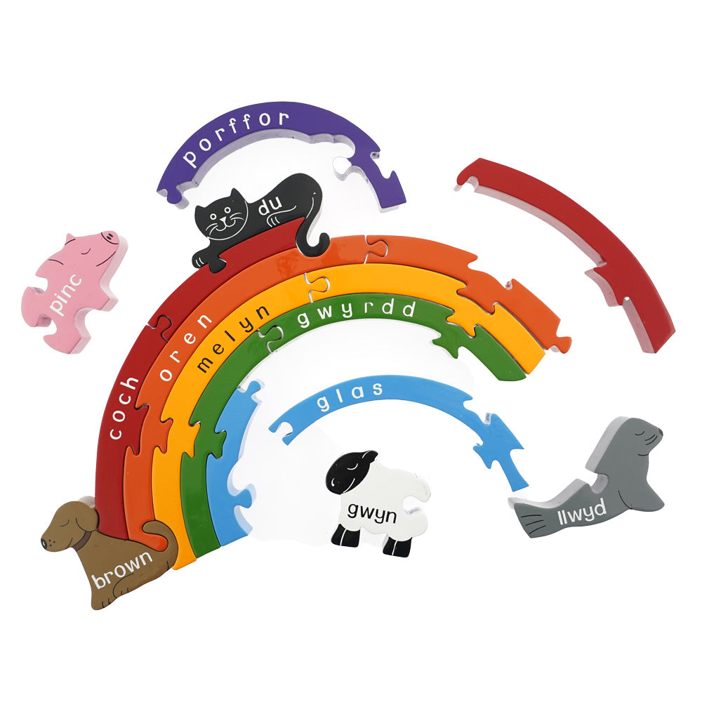 Pieces of the Alphabet Jigsaw eco-friendly wooden rainbow welsh puzzle scattered on a white background