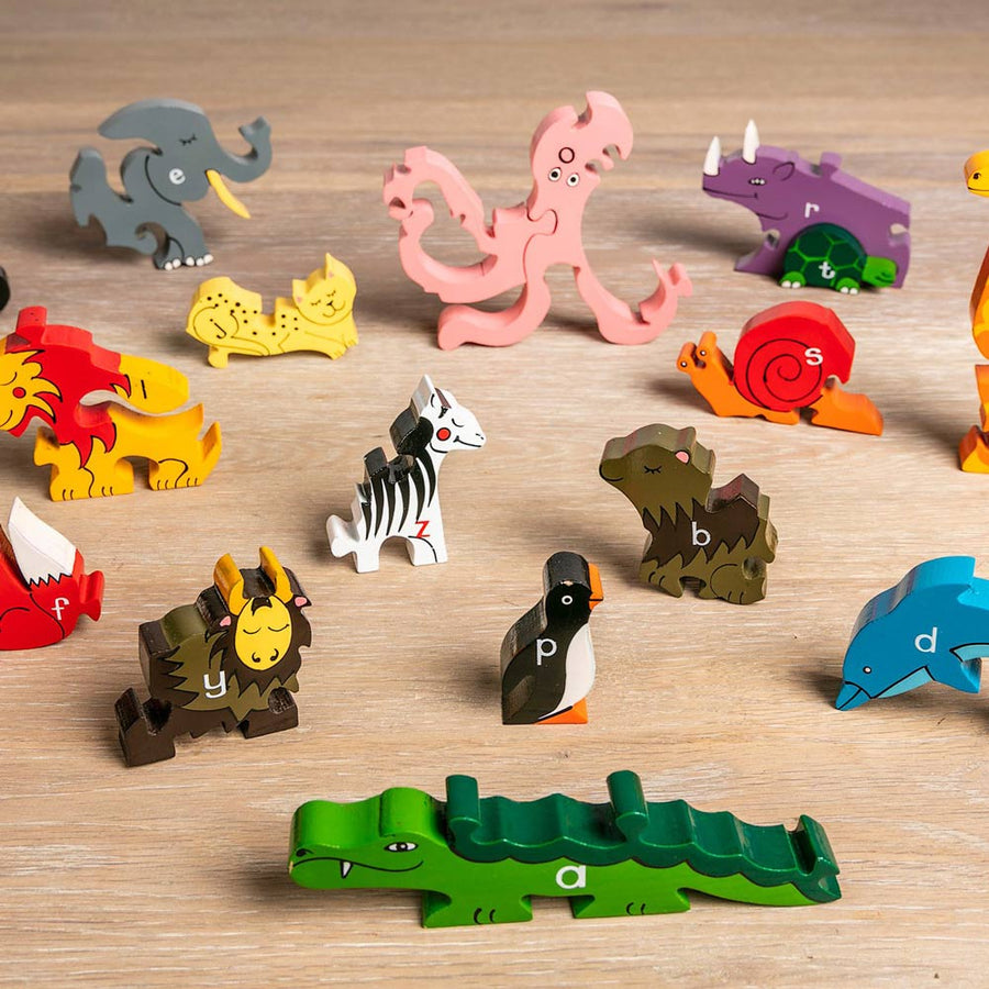 Alphabet Jigsaw 3D wooden animal puzzle pieces scattered on a wooden floor