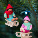 Ambrosius collectable boy on sledge Christmas decoration hanging from a stick on a white background