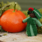 Ambrosius handmade Christmas yew fairy figure stood on some wood next to an orange and green moss