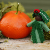 Ambrosius handmade Christmas yew fairy figure stood on some wood next to an orange and green moss