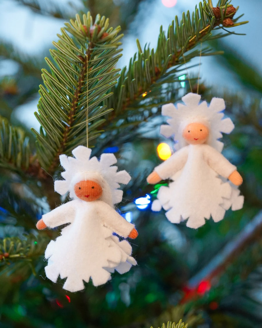 Close up of the Ambrosius handmade light brown skin snow crystal figure hanging on a Christmas tree