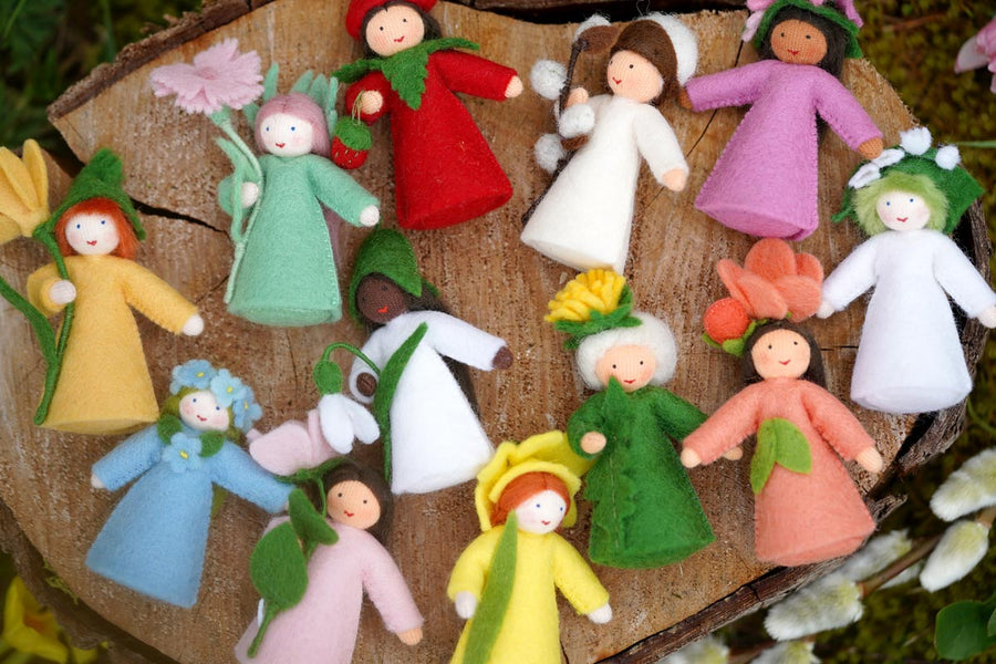 Ambrosius handmade spring fairy doll collection spread out on a wooden log