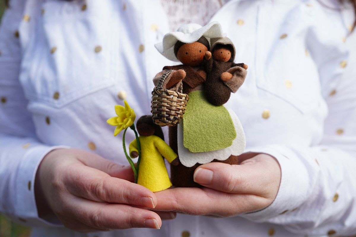 Close up of some hands holding the Ambrosius plastic-free mother earth and flower fairy figures