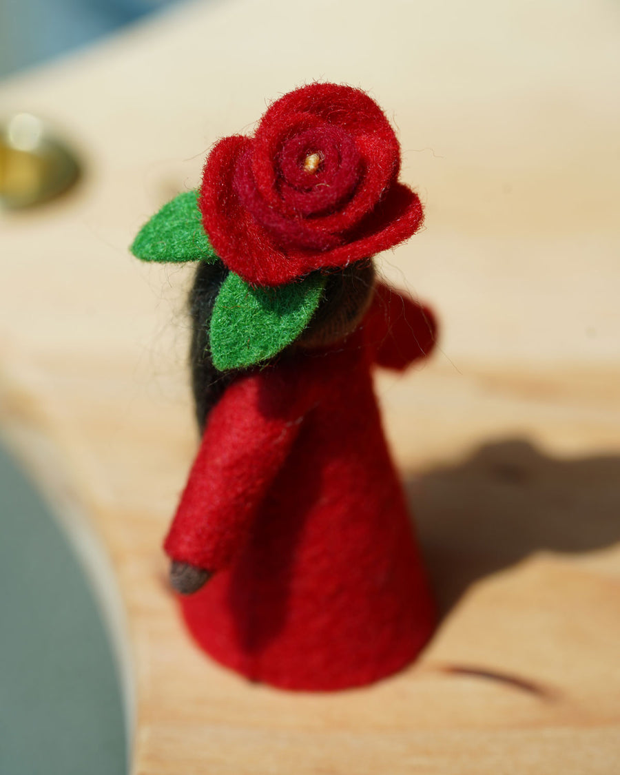 A close up of the red rose top on the Ambrosius felted fairy figure