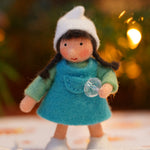 Ambrosius handmade felt winter dwarf girl figure in front of some blurry lights on a white floor