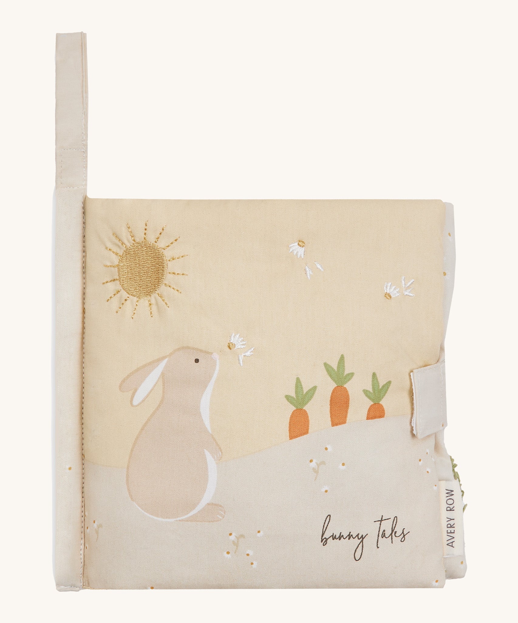 A soft beige Avery row baby book with a rabbit on the cover on a cream background.