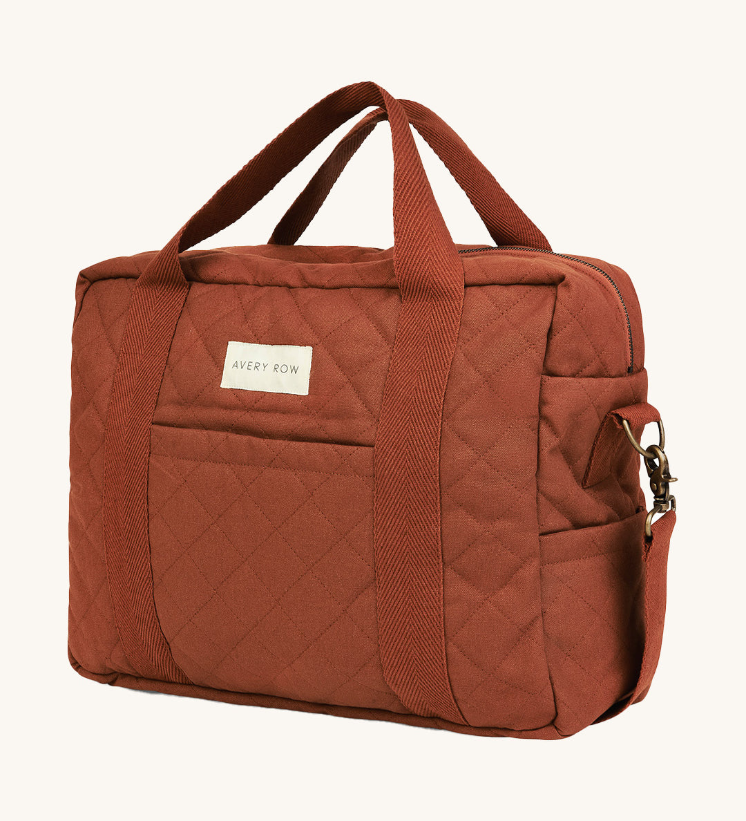 A orange and brown cinnamon coloured Avery Row baby changing bag on a cream background.